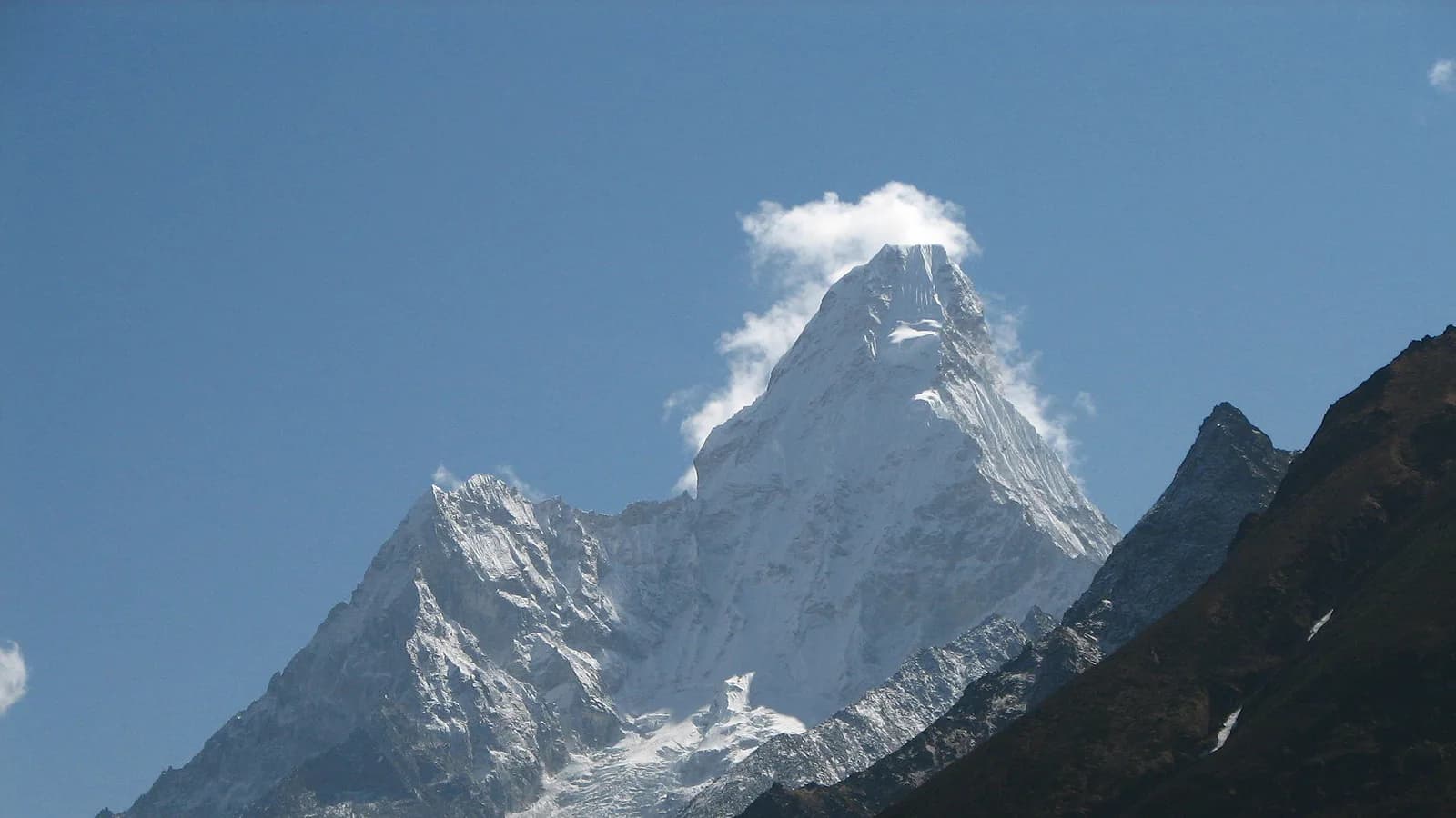 The snow-and-rock summit pyramid of Ama Dablam against a blue Himalayan sky