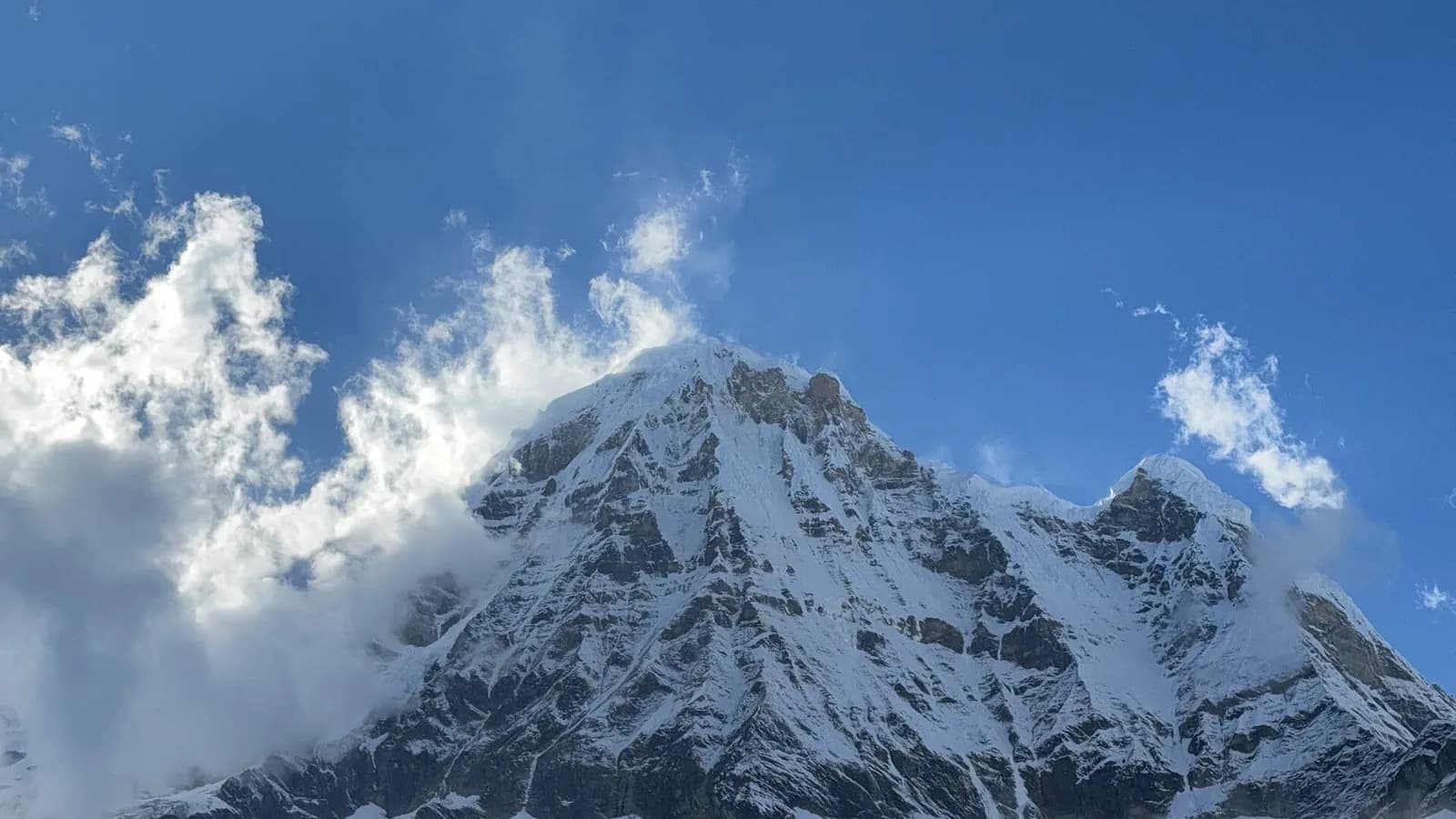 Panorama of the snow-dusted Annapurna massif rising above a broad Himalayan valley