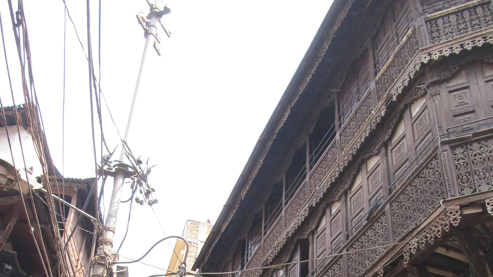 Traditional carved-wood Newari buildings lining a narrow old street in Kathmandu