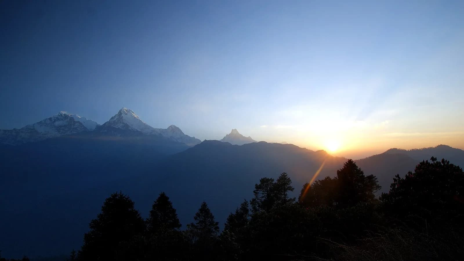 Sunrise over the snow-covered Annapurna and Dhaulagiri peaks seen from the Poon Hill viewpoint in Nepal.