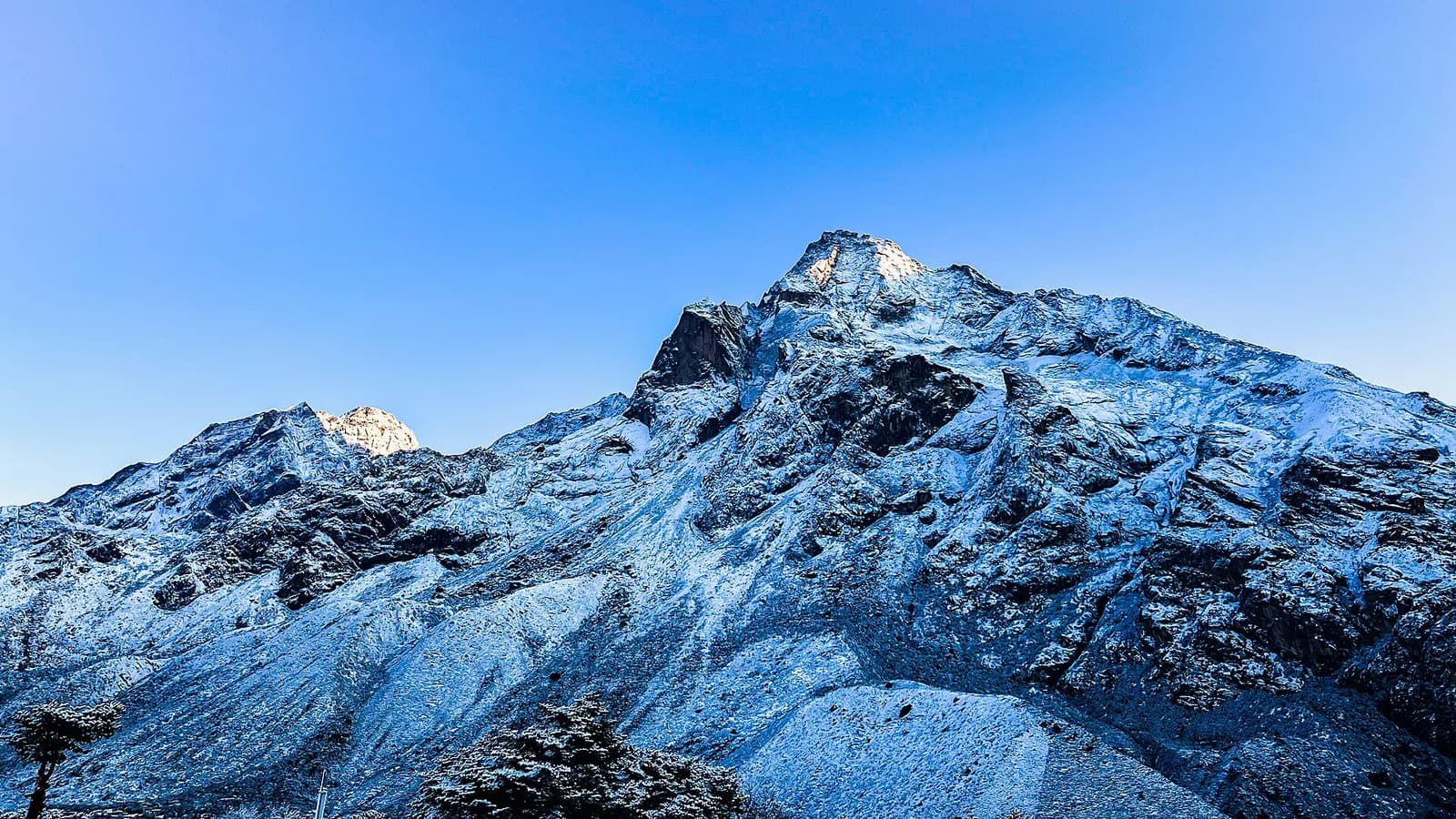 Wide panorama of the Mount Everest massif rising above the surrounding Himalayan peaks under a clear sky