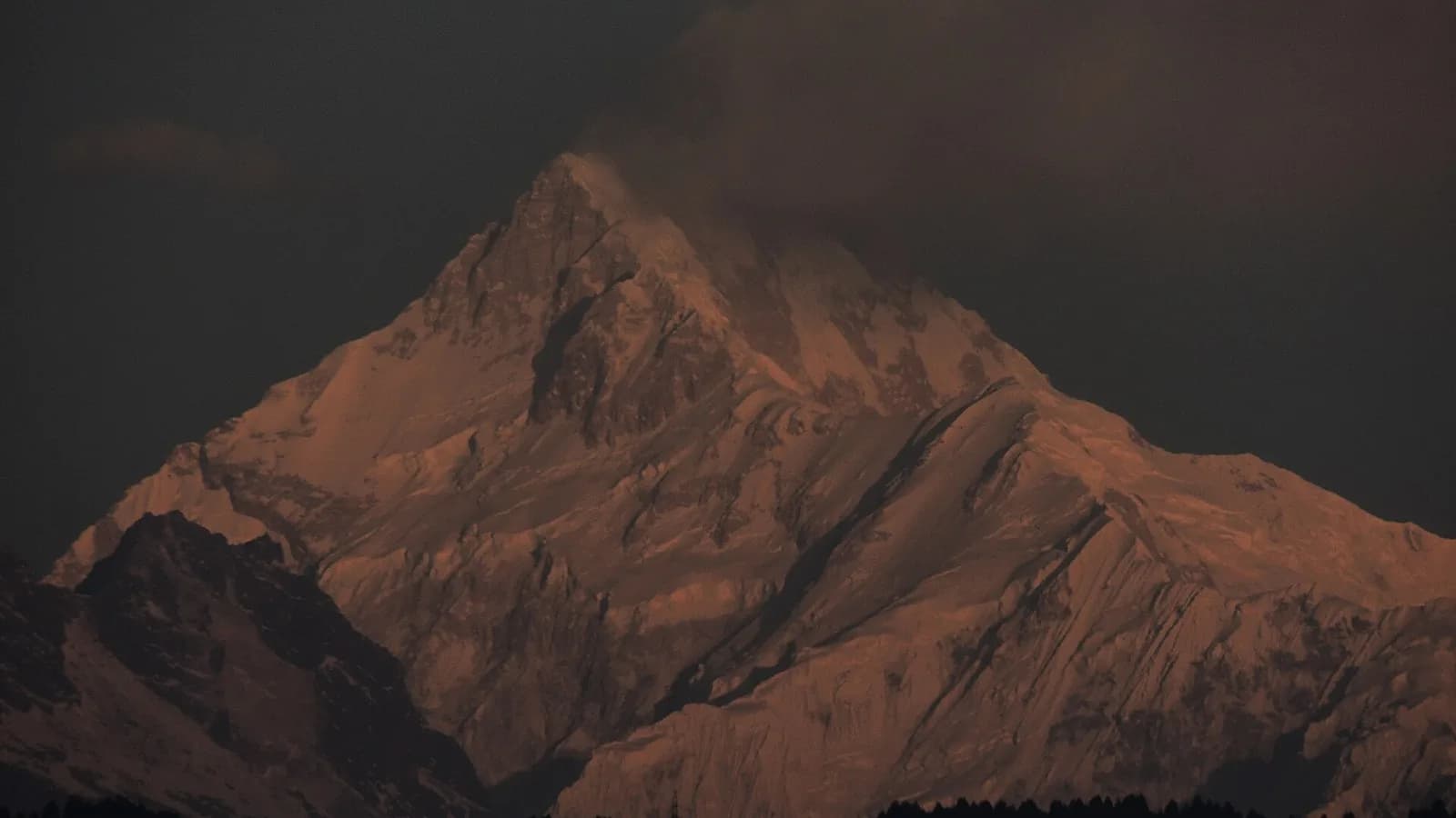 Snow-covered Himalayan peaks of Kanchenjunga rising above cloud, the kind of high-altitude terrain where helicopter evacuation may be the only way out