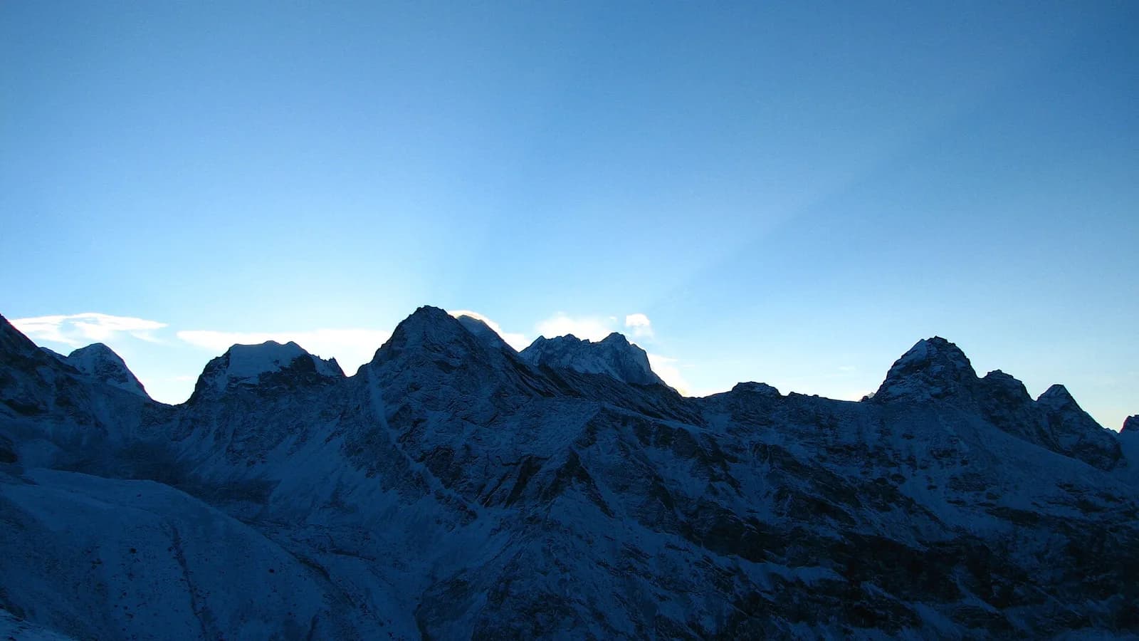 Snow-capped Himalayan peaks rising above the clouds, the high range that includes Mount Everest