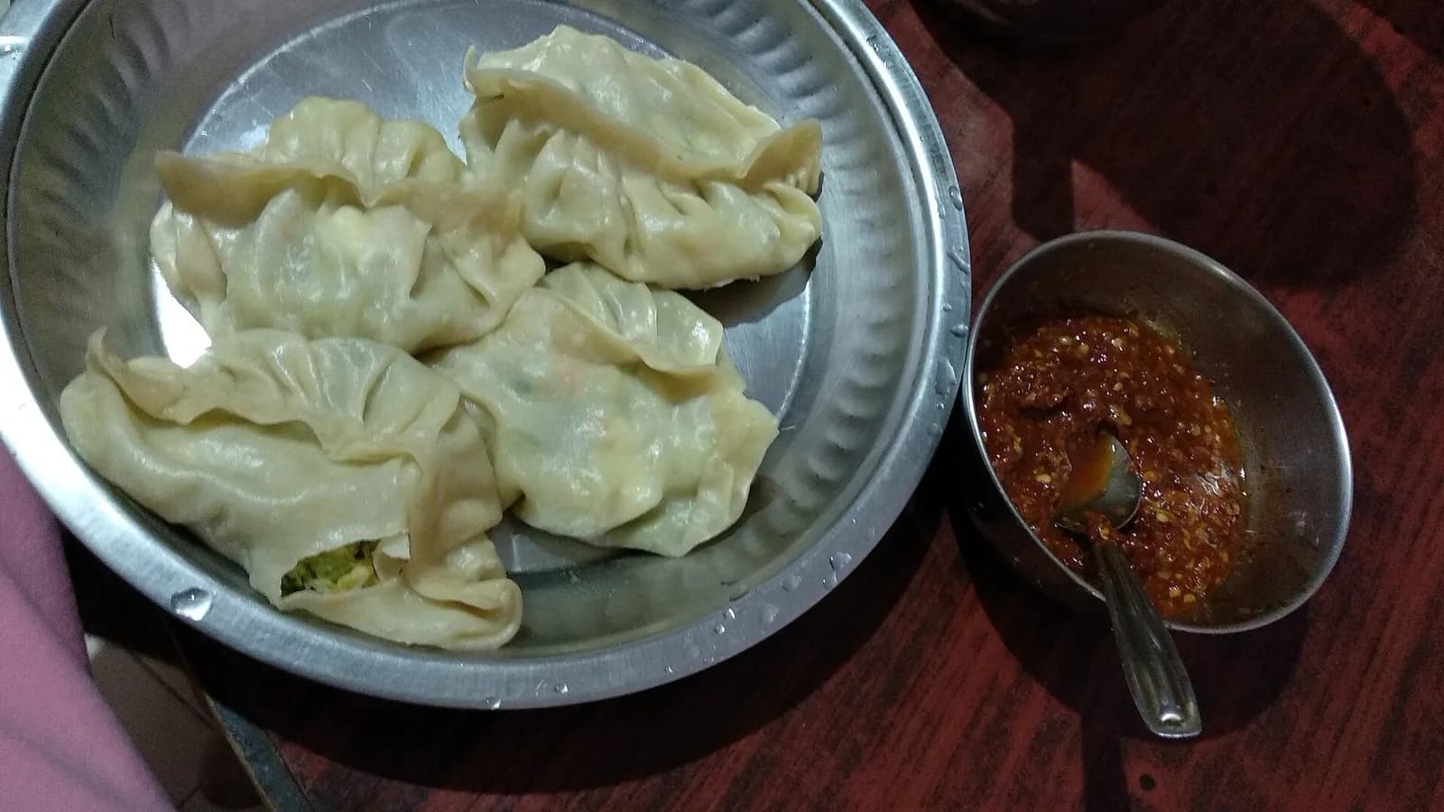 A plate of homemade momo dumplings with chutney