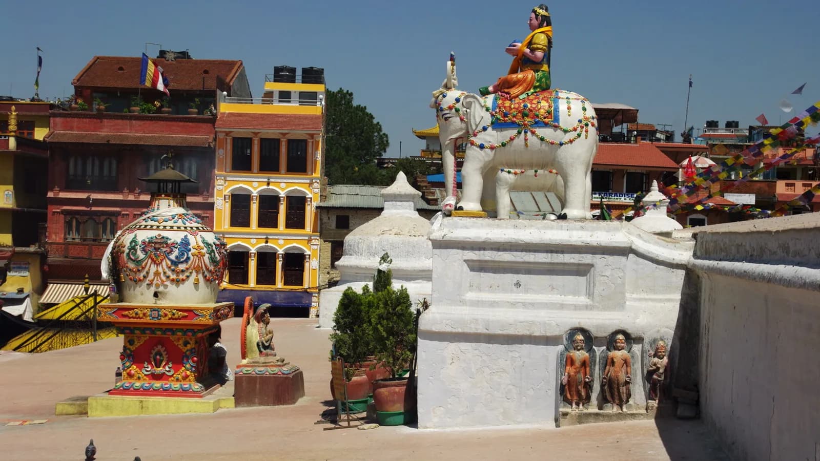 Detail of the gilded spire and painted eyes of Boudhanath Stupa rising above Kathmandu under a blue sky.