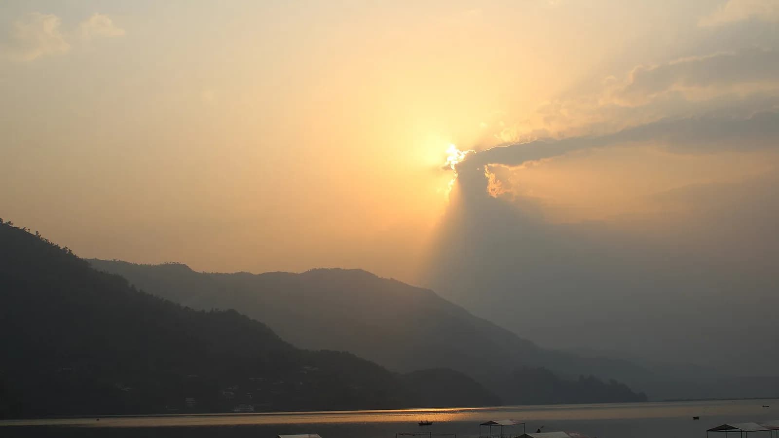 Phewa Lake in Pokhara with green hills behind it, the destination at the end of the drive from Kathmandu