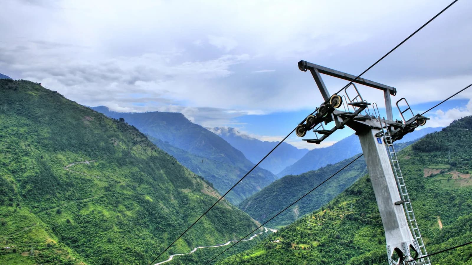 A red cable car gondola climbing the hillside toward Manakamana temple in Nepal