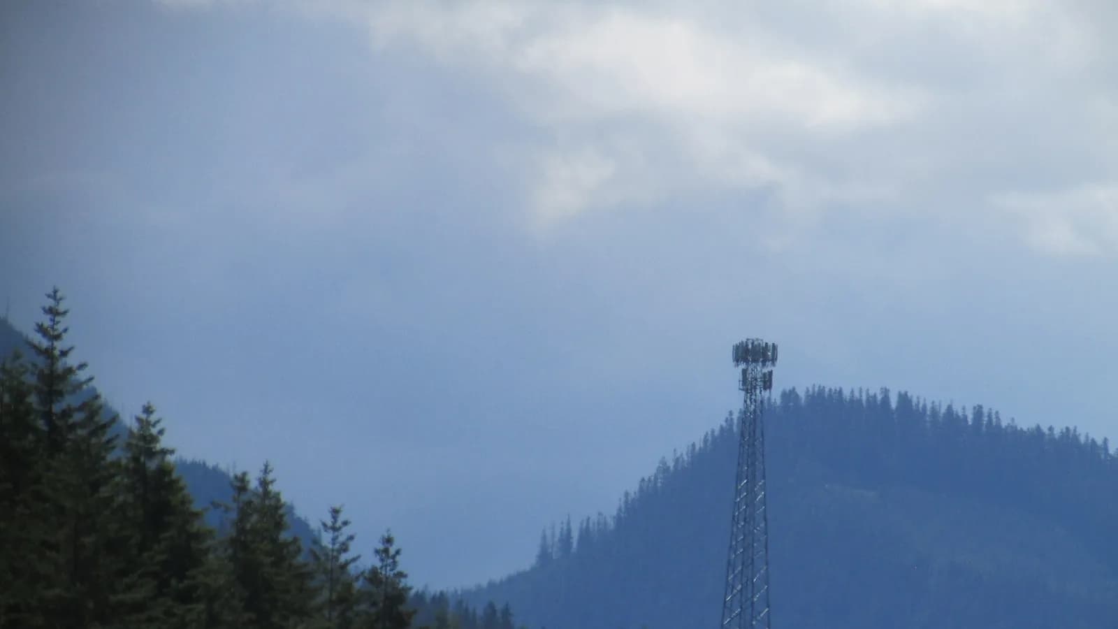 A mobile phone signal tower standing on an exposed mountain ridge, the kind of remote tower that decides whether your SIM has coverage on a Nepal trek.