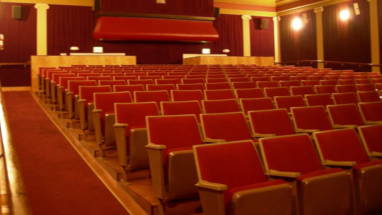 The interior main hall of a vintage cinema with rows of empty seats facing the screen