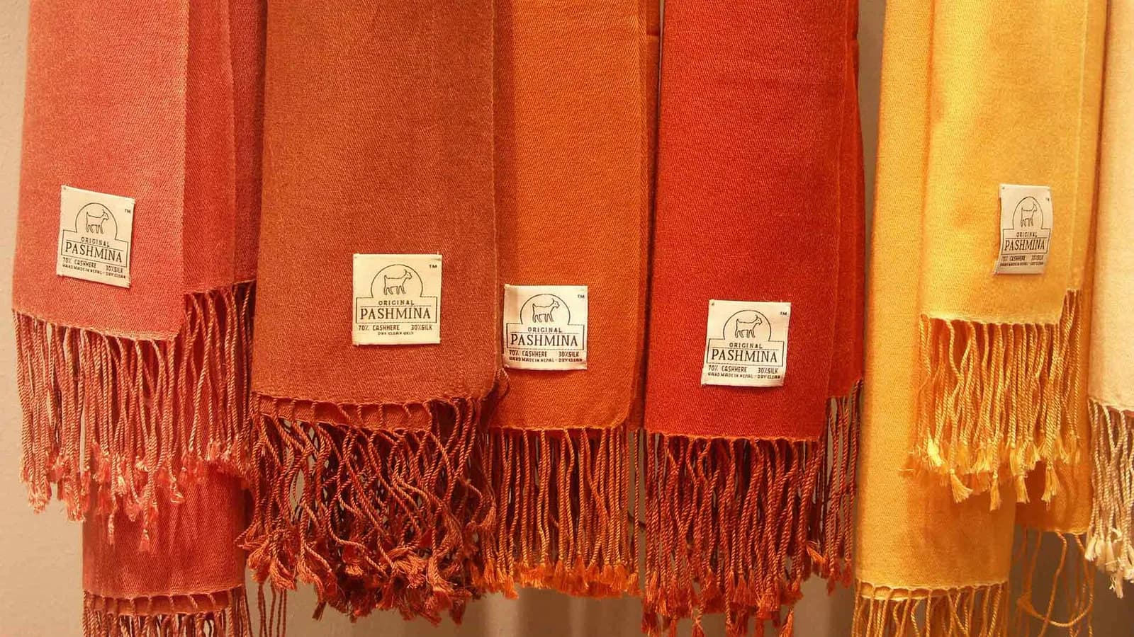 Folded pashmina shawls in natural tones, the signature handcrafted textile of Nepal